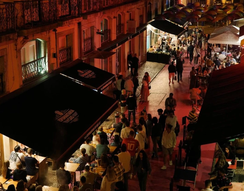 Nightlife on Pink Street in Lisbon with crowds and colourful bar fronts